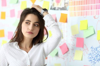 Güzel bir kadın iş yerinde saçını düzleştiriyor.