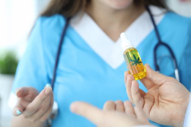 Doktor elinde kanabinoid yağıyla şişe tutuyor.