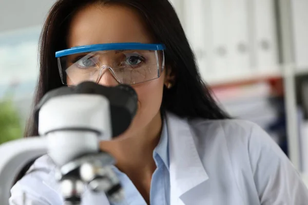 Hermosa ayuda madura utilizando microscopio científico — Foto de Stock