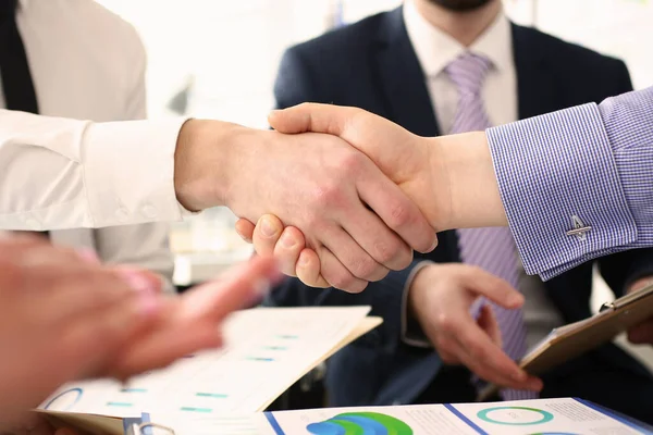 Group of businessmen shaking hands after productive meeting