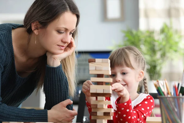 Mamma hjälper tålmodigt sin dotter att bygga struktur — Stockfoto