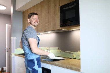 İş elbiseli mutlu adam mutfağa çadır kurar.