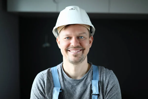 Hombre con ropa de trabajo en casco protector sonriendo —  Fotos de Stock