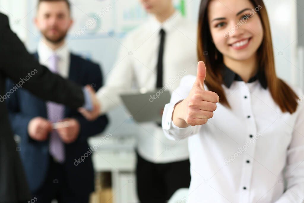 Woman showing confirm symbol during conference in office