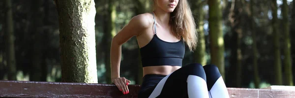 Meisje doet stretching spieren leunend op bank. — Stockfoto
