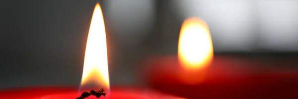 Zbliżenie płonącego knota świecy na tle ciemnej ściany — Zdjęcie stockowe