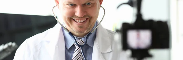 Médico sorridente mostra para ouvir os pulmões estetoscópio — Fotografia de Stock