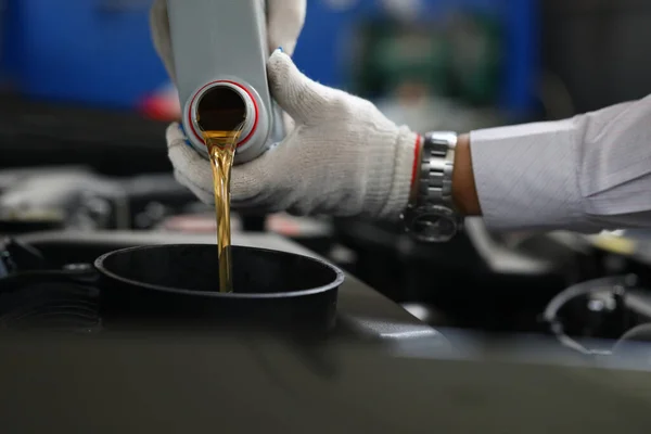 Närbild händer i handskar hälla olja i bilen tank — Stockfoto