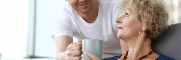 Hijo adulto sirve té taza a una madre anciana — Foto de Stock