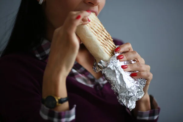 Mulher come shawarma saboroso em pão pita e papel alumínio — Fotografia de Stock