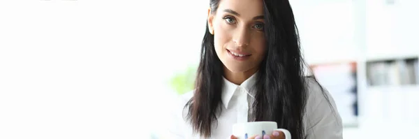 Fashionable woman is office and drinking coffee — Stock Photo, Image