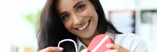 Sorrindo mulher segurando caixa em forma de coração — Fotografia de Stock