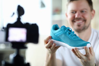 Mutlu adam ayakkabı sunar.