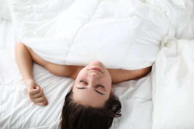 Çarşafların altında çıplak çekici bir kadın.