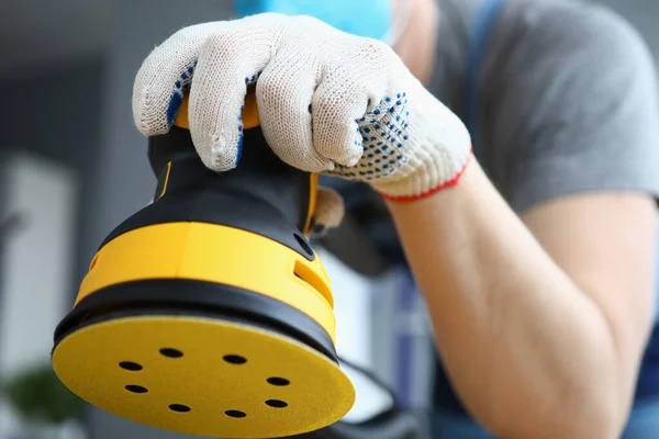 Male builder in work gloves holds sander machine — Stock Image Male builder in work gloves holds sander machine Stock Picture