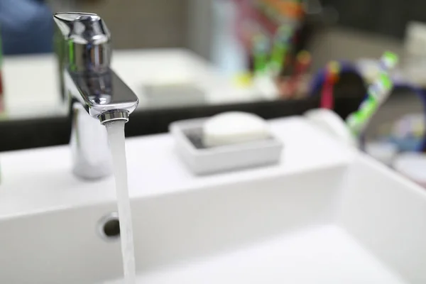 Áramló víz áramlik a csapból a fürdőszobai mosogatóba — Stock Fotó