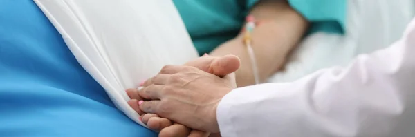 Laskavý lékař drží ruku vážně nemocného pacienta. — Stock fotografie