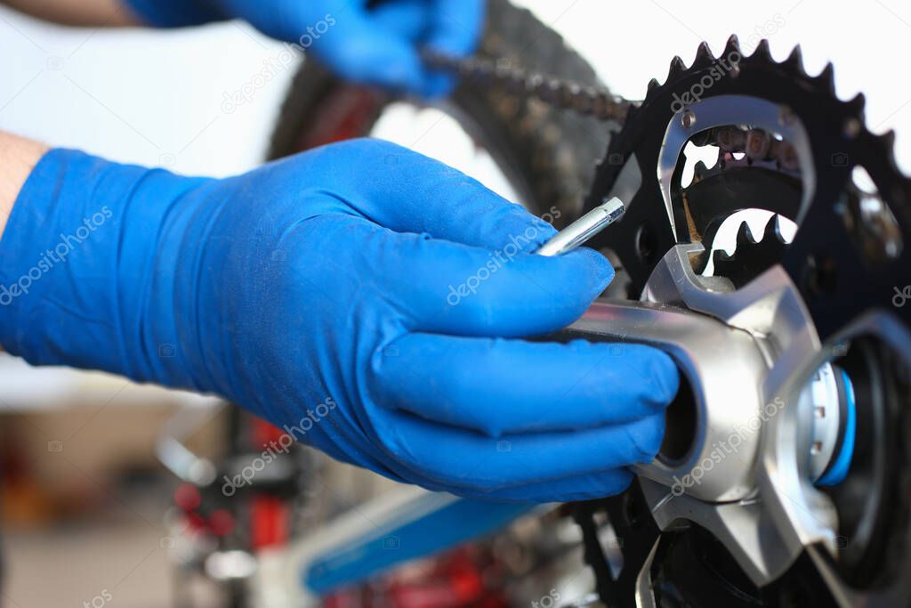 Gloved hands guy repair mechanical part bicycle