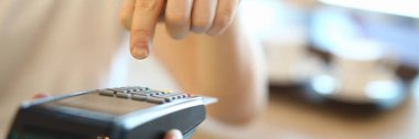 Man dials a PIN code at terminal, payment by card