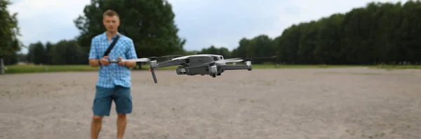 In foreground drone flies, guy controls drone — Stock Photo, Image