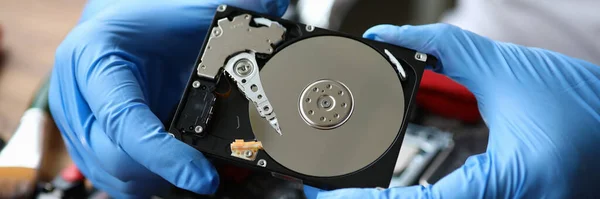 Las manos enguantadas muestran el disco duro del ordenador, necesitan reparación — Foto de Stock