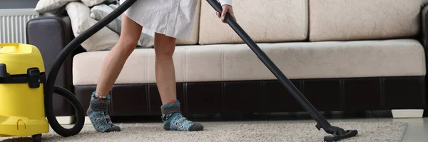 Woman with mask on her face vacuuming carpet — 스톡 사진