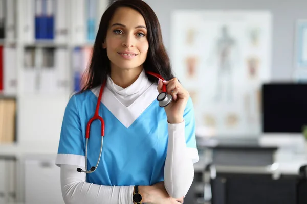 Медсестра в синем халате против фонового портрета в клинике — стоковое фото