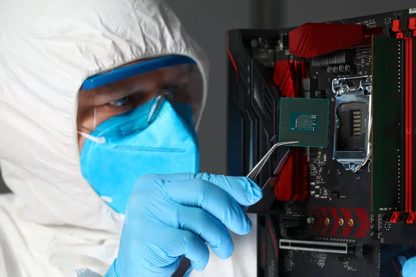 Man in uniform zet microchip elektronische apparatuur — Stockfoto