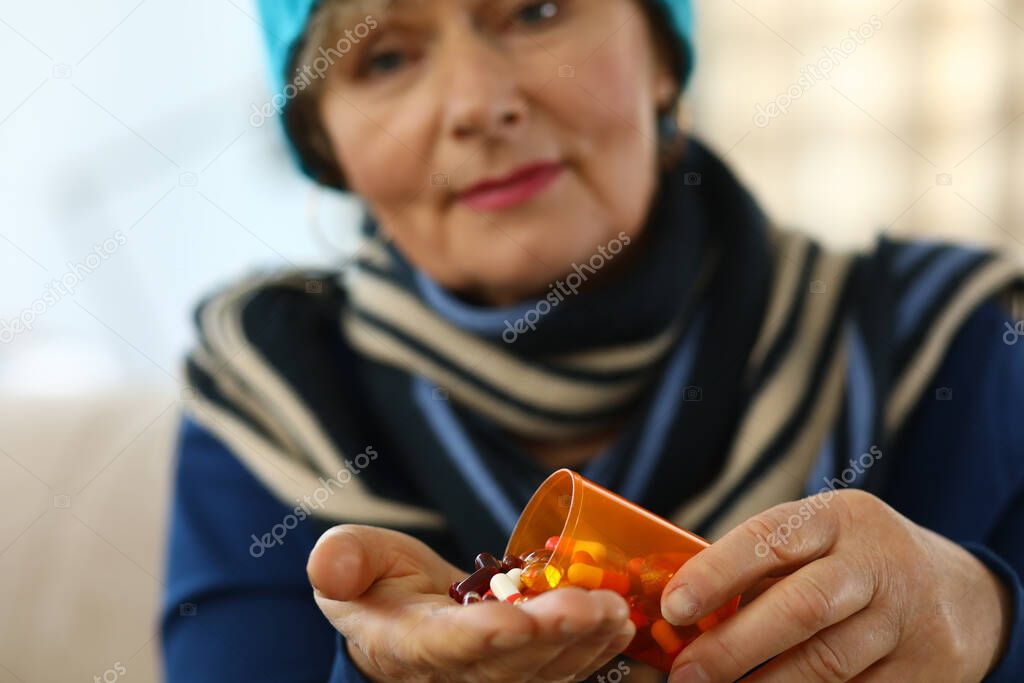 Cold elderly woman falls asleep on palm capsule