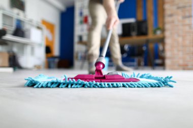 Erkek el, modern ofise karşı mavi plastik paspas tutuyor.