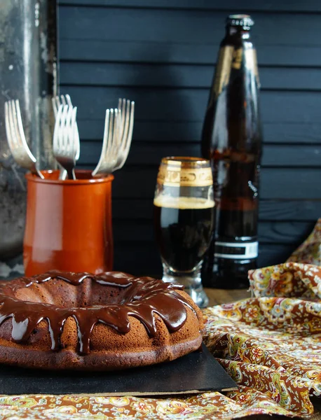 chocolate cake on the base of dark beer with chocolate icing and strawberries - dark rustic style