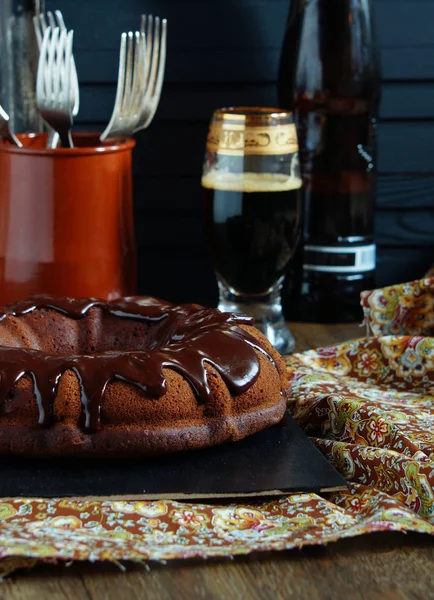 chocolate cake on the base of dark beer with chocolate icing and strawberries - dark rustic style