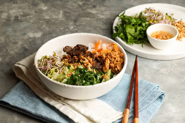 Bowl of traditional Vietnamese noodle salad - Bun Bo Nam Bo, with beef, rice noodles, fresh herbs, pickled vegetables and fish sauce — Stock Image Bowl Traditional Vietnamese Noodle Salad Bun Nam Beef Rice Noodles Stock Image