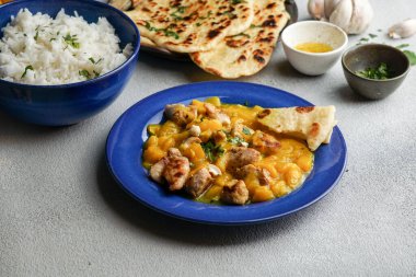 Tavuk ve kaju soslu mango körisi, sarımsaklı ekmek ve pilav.