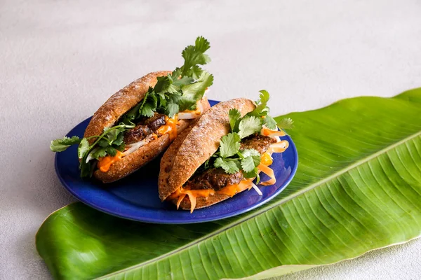 Banh Mi Sandviç, tipik Vietnam sandviçi, kişniş yaprağı, börek, et, salatalık, havuç turşusu ve muz yaprağında turşu.