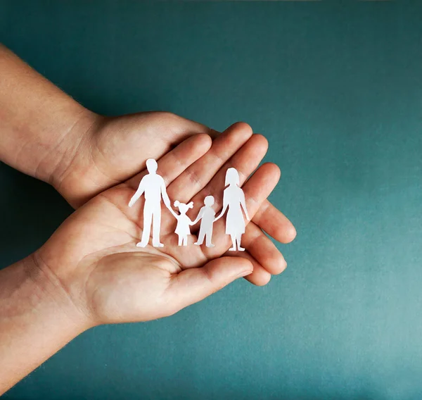 hands holding paper family cutout, social distancing concept, covid19 on the blue color background