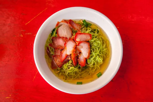 Green noodle soup on red background. Thai food. Food and health.