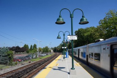 Bir banliyö tren platformu bir tren bir tarafta ve diğer boş parçaları ile aşağı bakıyor.