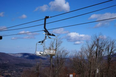 Boş Kayak asansör sandalye ağaçlar ve dağlar içinde belgili tanımlık geçmiş.