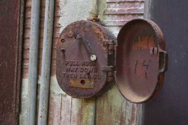 Vintage fire alarm box in an abandoned building.