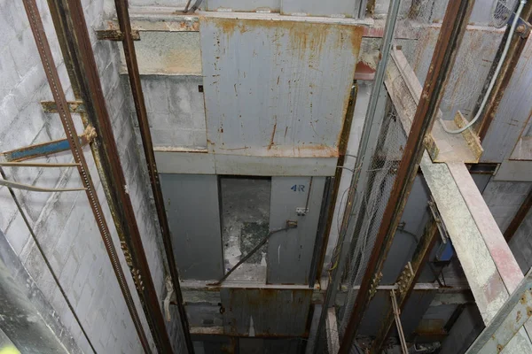 Looking down an empty elevator shaft in an abandoned hospital building.