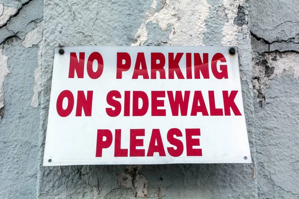 贴在建筑物墙壁上的人行道上的金属禁止停车标志 — 图库照片