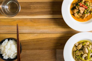 Domuz eti baharatlı köri ve kızarmış yağlı mantar köri ve yemek masası üzerinde yer.