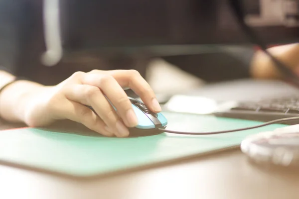 The hand is caught the mouse and is working in the office