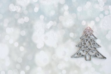 Yılbaşı kartı, parlak pastel arka planda gümüş Noel ağacı..