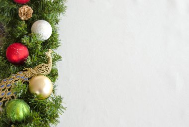 Noel arkaplanı, yeşil çelenk, beyaz arka planda Noel ağacı süslemeleri..