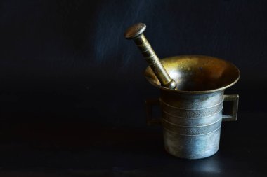 Heavy golden mortar on a black background.