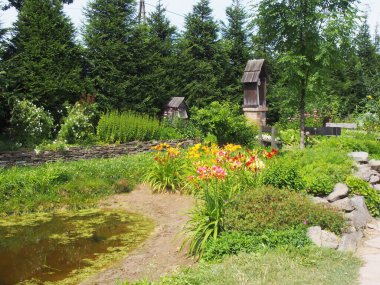 İklim bahçesi kırsal tarzı, yataklar, çiçekler, ağaçlar ve çalılar.