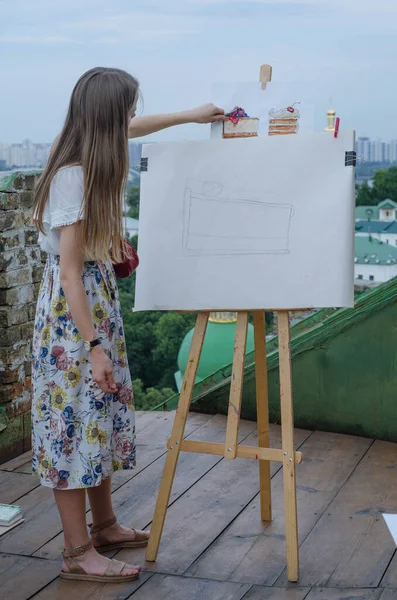Watercolor artist painting on the roof. Filmed on retro soviet lens helios 44 m.