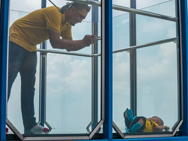 Babası alarak fotoğraf Kl Tower, Kuala Lumpur şeffaf cam katta oğlu